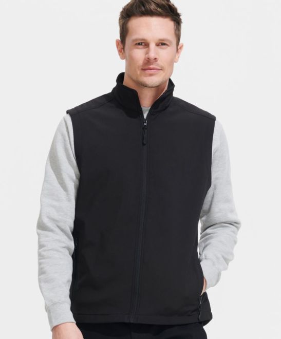 Moški dvoslojni softshell brezrokavnik SOL'S Race BW, črn z zadrgo in žepoma, prikazan na modni model na sliki.